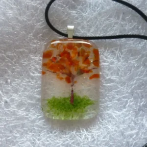 Autumn tree pendant, large oblong clear glass with copper tree trunk and orange leaves / petals, green at bottom for the grass. 925 sterling silver bail and black cord necklace.