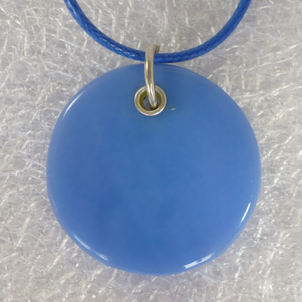 Back of blue round glass pendant, sterling silver grommet and jump ring.