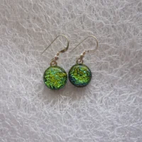 Green earrings made up of dichroic glass cabochons attached to 925 sterling silver ear wires.