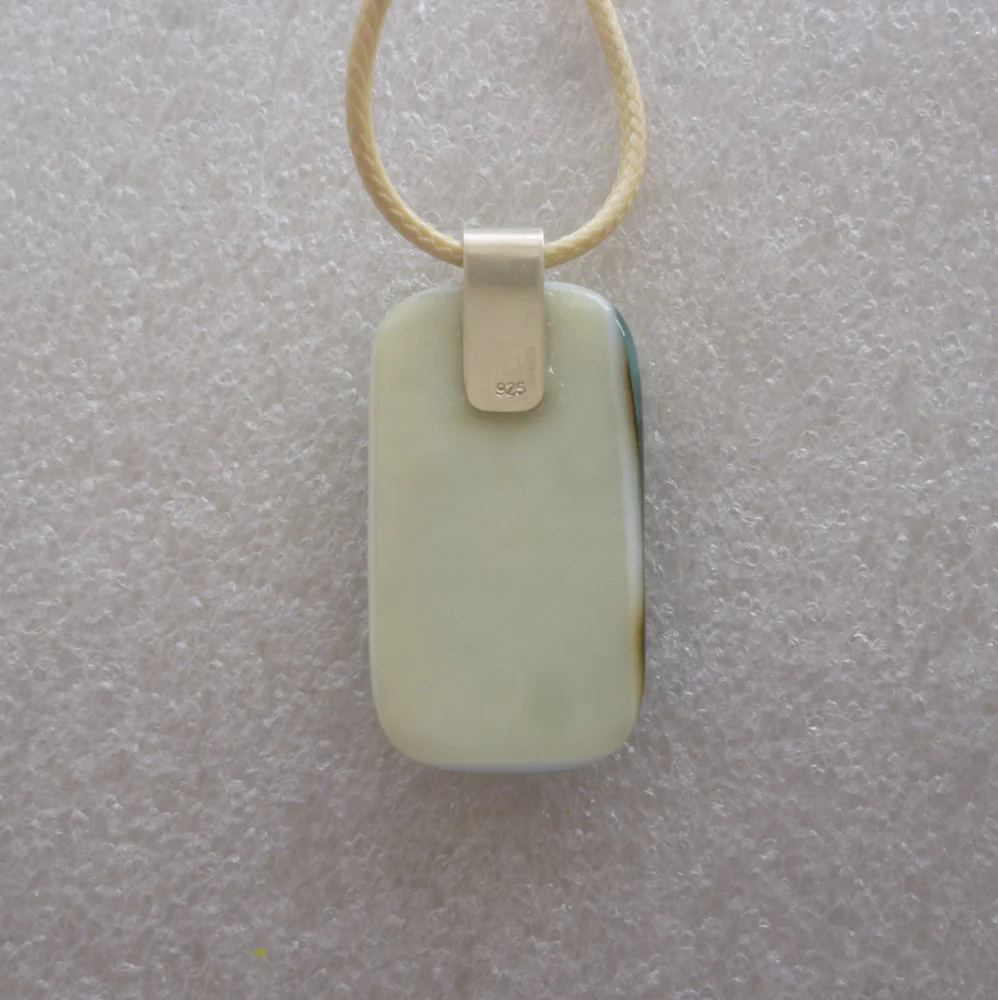 Back of pendant is cream showing 925 sterling silver bail