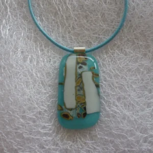 Turquoise blue reactive glass pendant with white and brown pattern made by the chemical reactions within the glass and hangs from a blue cord necklace.