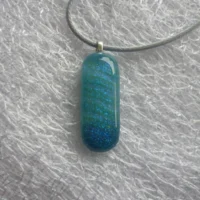 Small oblong blue pendant made with dichroic glass, 925 sterling silver bail and grey cord necklace.