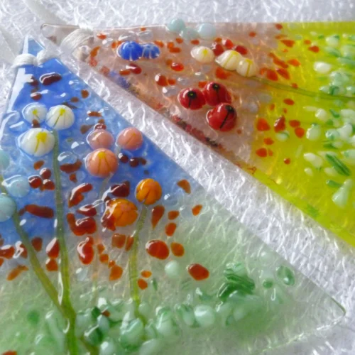 Close up of tactile fused glass suncatchers at an angle.