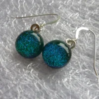 Close up of green dichroic cabochons attached to dangle earrings with 925 sterling silver earwires.