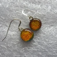 Orange dangle earrings with dichroic glass cabochons attached to silver plated bails and 925 sterling silver ear wires.
