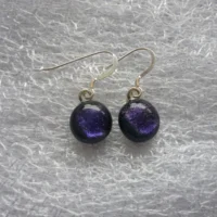 Earrings with purple dichroic glass cabochons attached to silver plated bails and 925 sterling silver ear wires.