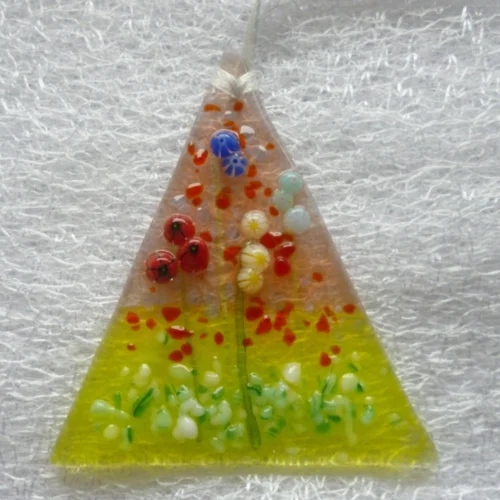 Small triangular flower suncatcher with fused glass flowers and stems. Flowers are in colours of blue, red and white. Hanging from a white ribbon.
