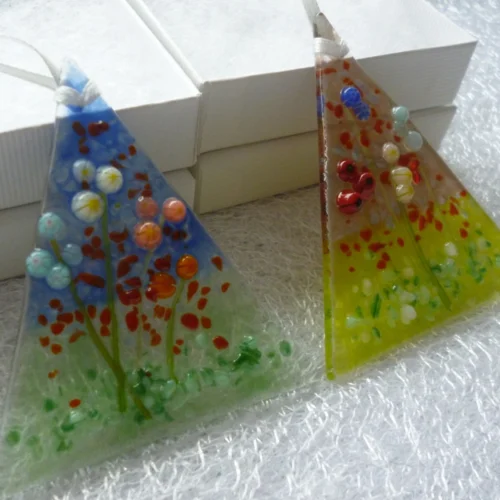 Small flower suncatcher standing against white gift boxes. Suncatchers are very tactile.