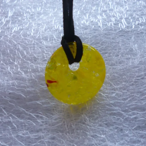 Yellow donut pendant standing upright, you can see through the pendant. Black cord necklace attached.