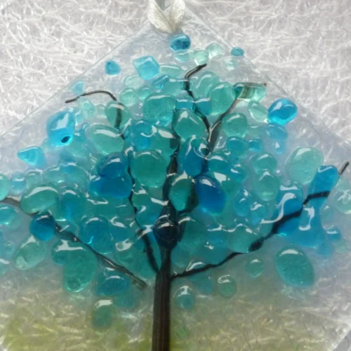 Close up of small suncatcher with colours of blue and turquoise for the blossoms of a winter tree.