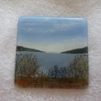 square hand painted coaster with hills and flowers.