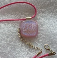 Sparkly pink dichroic glass pendant with bright pink cord.