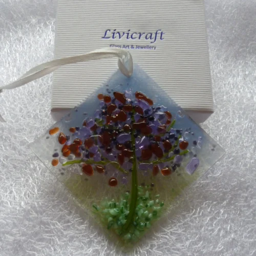 Small suncatcher leaning against a gift box.
