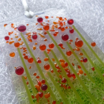 Close up of very tactile red and orange beads with green stringers for stems.