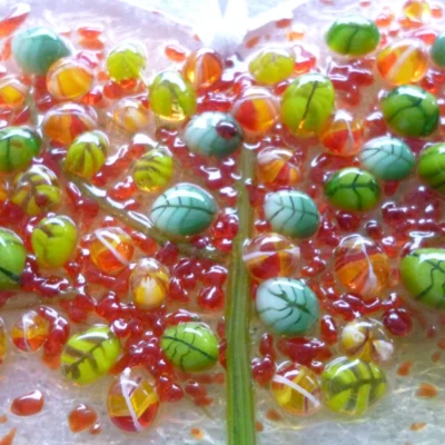 Close up of tactile leaves in different shades of green, orange and red for an autumn tree heart suncatcher. This is a very tactile design.
