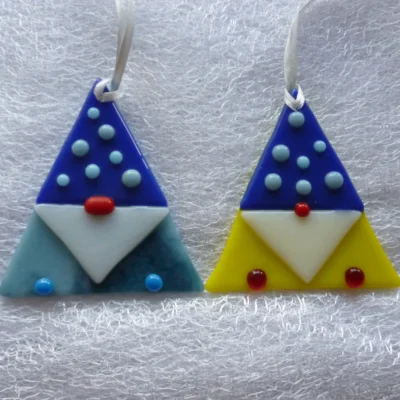 Two fused gonks in blue and yellow laying on a white cloth.