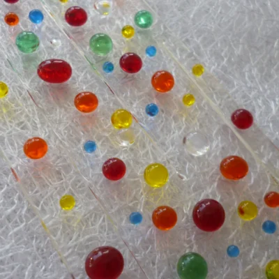 Close up of suncatcher with glass beads in colours of red, orange, yellow, blue, green and clear.