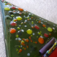 Close up of glass Christmas tree with colourful frit for decoration.