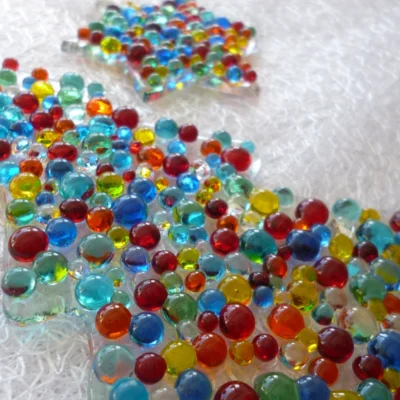 Close up of colourful glass beads on fused glass tree and star.
