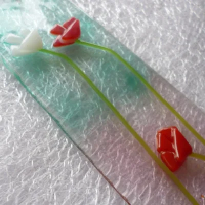 Close up of glass flower suncatcher showing detail of flowers.