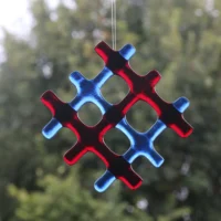 Transparent red and blue glass in a lattice pattern, hanging from a clear cord.