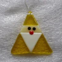 Quirky yellow iridised glass Santa in a triangular shape, with a white beard and red nose hanging from a white ribbon. The irid glass gives Santa a little bit of a shimmer