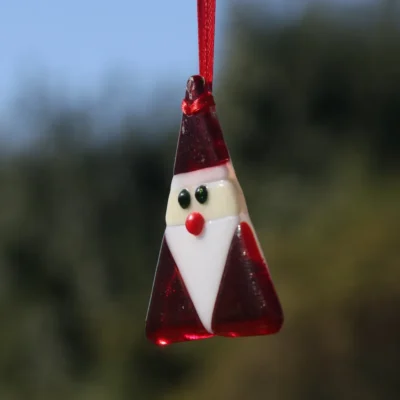 Fused glass Santa Claus side view. Triangle shaped Santa hanging from red ribbon.