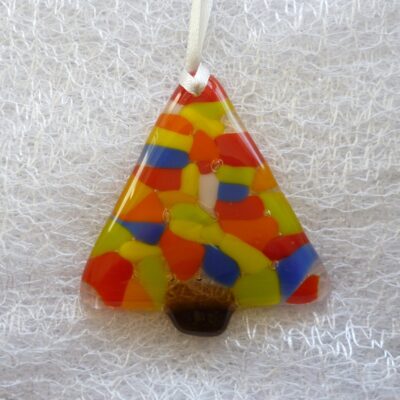 single colourful Christmas tree decoration laying on a white cloth.