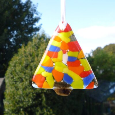 Single fused glass colourful Christmas tree with colours of blue, yellow, orange, green red and white, hanging from a white ribbon.
