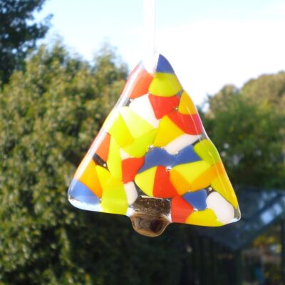 fused glass triangle shaped colourful Christmas tree with colours of blue, yellow, orange, green red and white. Hanging from a white ribbon.