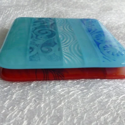 One blue and one red coasters stacked on top of each other