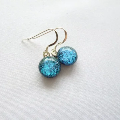 Sparkly blue teal dichroic cabochon earrings with 925 sterling silver ear wires attached.