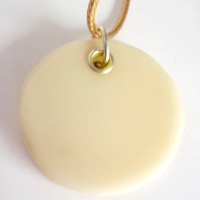 Back view of round beige dichroic glass pendant with sterling silver grommet