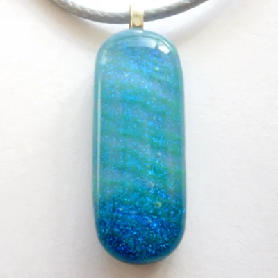 Close-up of blue dichroic glass pendant with glossy finish