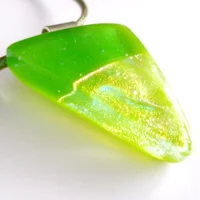 Close up of sparkly handmade green dichroic fused glass pendant with sterling silver bail