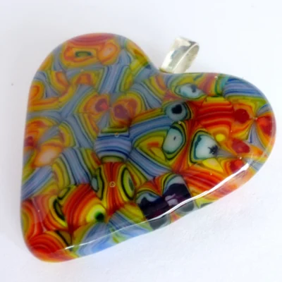 Close up and side view of large colourful fused glass heart pendant with sterling silver bail