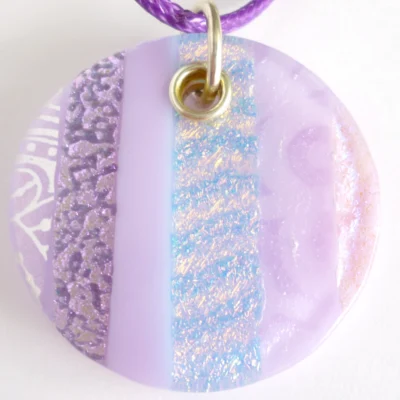 Close up of handmade lilac dichroic fused glass pendant with sterling silver fitting