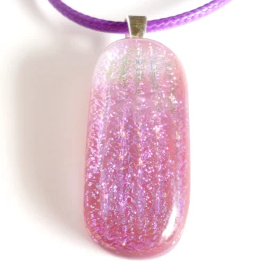Close up of handmade purple and pink fused glass pendant with sterling silver bail