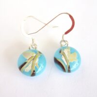 Reactive glass earrings with round blue cabochons attached to silver plated bails and sterling silver ear hooks.