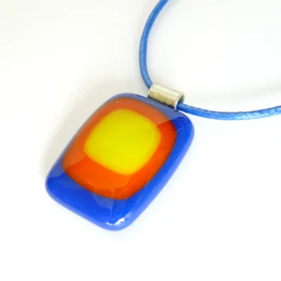 Blue red and yellow pendant at an angle on a white background