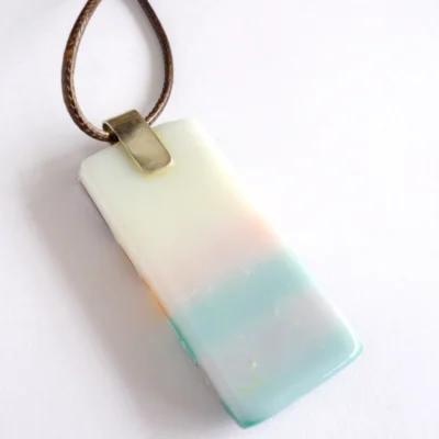 Back of seascape fused glass pendant with a base of white glass and sterling silver bail attached