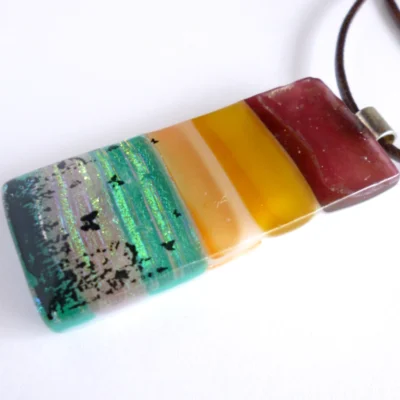 Side view of seascape fused glass pendant showing depth of glass