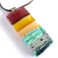 Close up of brown and orange seascape fused glass pendant with sterling silver bail and brown cord necklace.