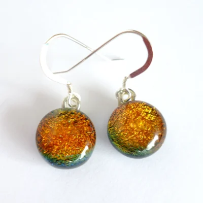 Fiery orange dichroic glass earrings with sterling silver ear wires and silver plated bails.