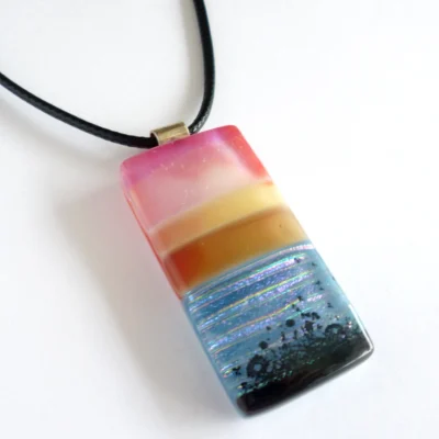 Pink and blue seascape fused glass pendant with sterling silver bail and black cord necklace.