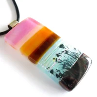 Handmade pink and brown seascape fused glass pendant with flower and grass decal fused on top