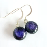 Purple dichroic glass earrings with round cabochons. Sterling silver ear hooks attached.