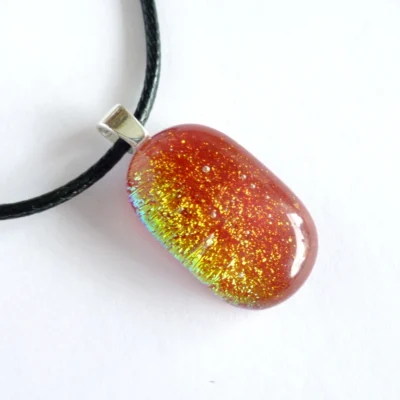 Red dichroic glass pendant with shimmers of yellow, green, red and orange
