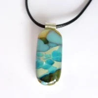 Fused vanilla and turquoise blue reactive glass pendant necklace on a white background