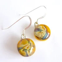 Yellow reactive glass earrings with a marble effect on top and 925 sterling silver ear hooks attached.